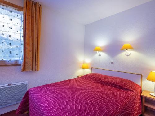 a bedroom with a red bed with two lamps on it at Appartement La Plagne, 2 pièces, 6 personnes - FR-1-353-72 in La Plagne