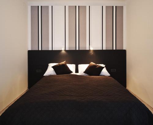 a bedroom with a large bed with two pillows at Design Studios SVI-MI in Zagreb