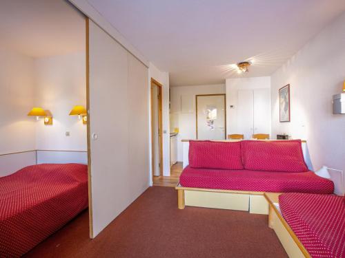 ラ・プラーニュにあるAppartement La Plagne, 2 pièces, 4 personnes - FR-1-353-46のベッド2台と赤いソファが備わる客室です。