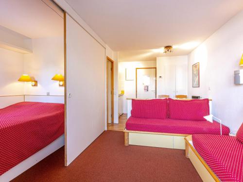 ラ・プラーニュにあるAppartement La Plagne, 2 pièces, 4 personnes - FR-1-353-44のベッド2台と赤いソファが備わる客室です。