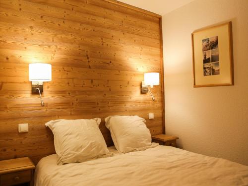 ラ・プラーニュにあるAppartement La Plagne, 3 pièces, 6 personnes - FR-1-353-42の木製の壁のベッドルーム1室(枕2つ付きのベッド1台付)