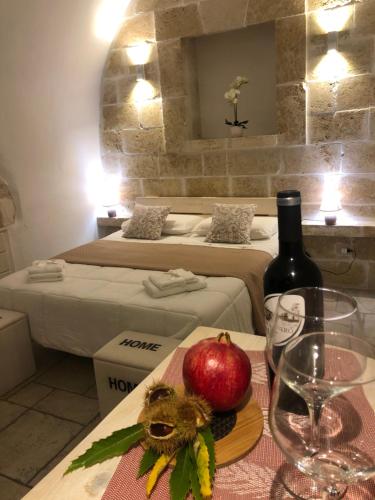 - une table avec une pomme et une bouteille de vin dans l'établissement Casetta dello Scrittore, à Ostuni