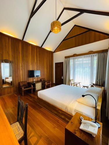 a bedroom with a bed and a desk with a phone at Bagan Cottage Boutique Hotel in Nyoungoo