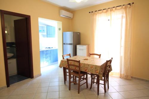 eine Küche mit einem Tisch mit Stühlen und einem Kühlschrank in der Unterkunft Case Gabbiano (by Vacation Service) in Cefalú