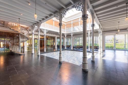 a large room with columns in a building at Ramada Plaza by Wyndham Chao Fah Phuket in Phuket Town