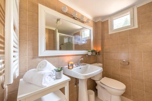 La salle de bains est pourvue d'un lavabo, de toilettes et d'un miroir. dans l'établissement Chalet de charme avec Ponton privé et Accès direct au lac, 4ch 8 pers, Exclusivité LLA Selections by Location lac Annecy, à Veyrier-du-Lac