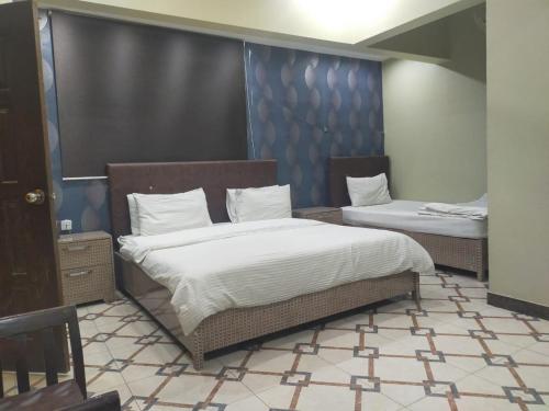卡拉奇的住宿－Karachi Guest House，配有两张床的宿舍间内的两张床