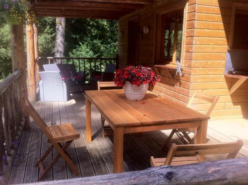 - une table et des chaises en bois sur la terrasse couverte d'une cabine dans l'établissement Le chalet de Cavailla, à Marmont-Pachas