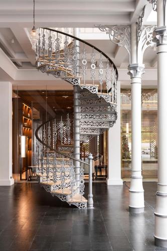 a spiral staircase in a building with a chandelier at Ramada Plaza by Wyndham Chao Fah Phuket in Phuket Town