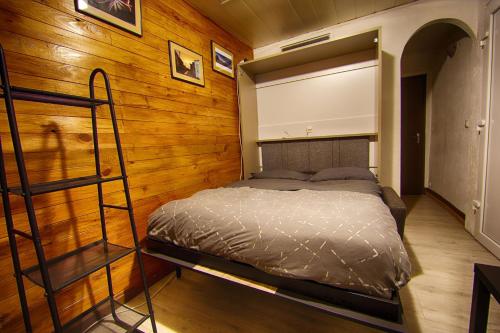 - une chambre avec un lit dans un mur en bois dans l'établissement T1 situé à 100 m des thermes, à Aix-les-Bains