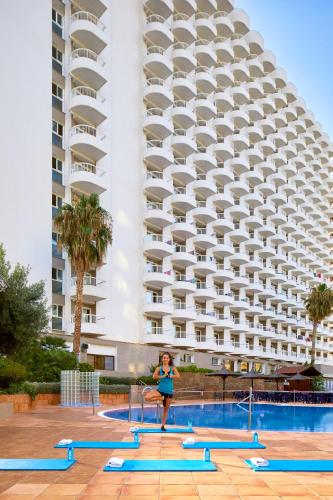 a woman standing in front of a large building at Sol Pelicanos Ocas in Benidorm