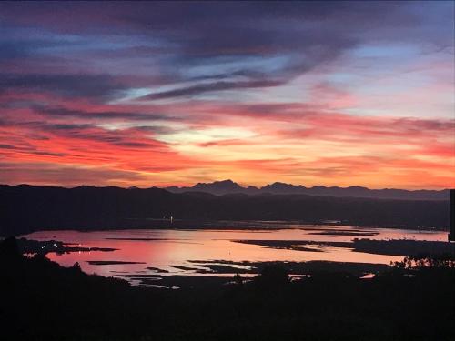 a sunset over a large body of water at Pezula Golf House in Knysna
