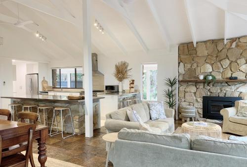 a living room with two couches and a stone wall at Yungarra Estate in Dunsborough