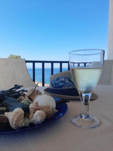 een glas wijn naast een bord eten bij Perdika Sea Soul in Perdhika