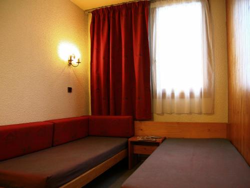 ラ・プラーニュにあるAppartement La Plagne, 1 pièce, 4 personnes - FR-1-353-10のリビングルーム(赤いソファ、窓付)