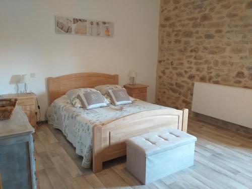 ein Schlafzimmer mit einem Bett und einer Steinmauer in der Unterkunft LA GRANGE DU RIAL in Bournazel
