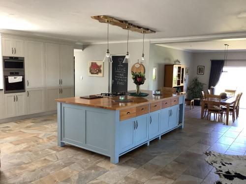 a kitchen with white cabinets and a wooden counter top at Pezula Golf House in Knysna