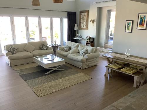 a living room with a couch and a coffee table at Pezula Golf House in Knysna