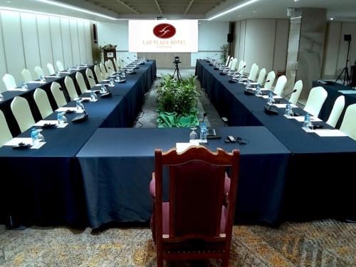 a group of long tables in a room with chairs at Lao Plaza Hotel in Vientiane