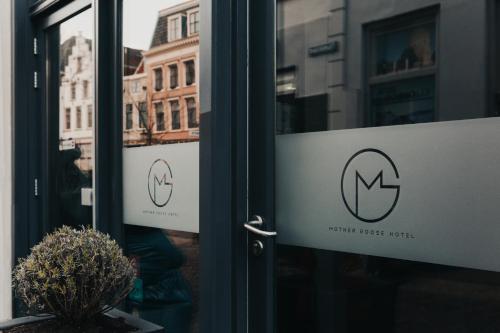 a sign on the door of a store at Mother Goose Hotel in Utrecht