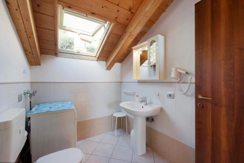 een badkamer met een wastafel, een toilet en een raam bij Trilocale in villa Apt 5 in Varazze
