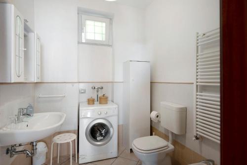 biała łazienka z pralką i umywalką w obiekcie Trilocale in villa vista mare Apt 3 w mieście Varazze