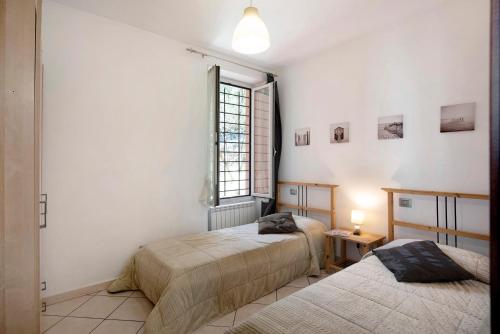 sypialnia z dwoma łóżkami i oknem w obiekcie Trilocale in villa vista mare Apt 3 w mieście Varazze