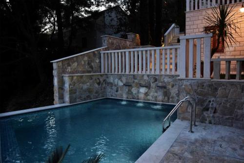 a swimming pool in a backyard at night at Luxury Beachfront Villa Palazzo di Mare with private heated pool and staff at the beach on Brac island - Sumartin in Selca