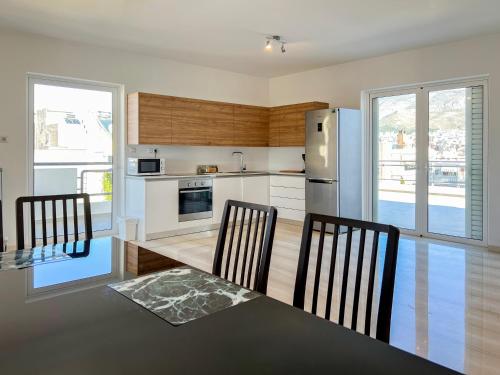 a kitchen with a table and chairs and a refrigerator at Panoramic Cityscape Maisonette in Agios Dimitrios in Athens