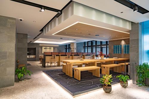 a dining room with a large table and benches at Oakwood Hotel Oike Kyoto in Kyoto