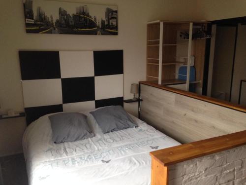 - une chambre avec un lit et un mur en damier dans l'établissement Studio très confortable, à Limoges