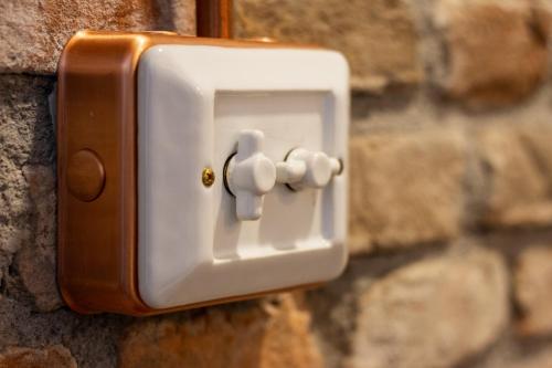 a light switch on a stone wall at Maison di Lidia - Smart Holiday in Mantova