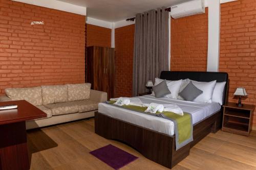 a bedroom with a bed and a couch at Nelinsa Resort and Spa in Matale