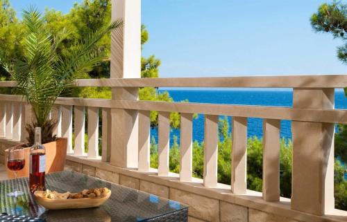 a table with a bowl of food on a balcony with the ocean at Luxury Beachfront Villa Palazzo di Mare with private heated pool and staff at the beach on Brac island - Sumartin in Selca