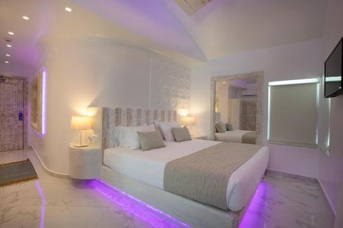 a white bedroom with a large bed with purple lights at Rhodos Horizon Blu-Adults Only in Rhodes Town