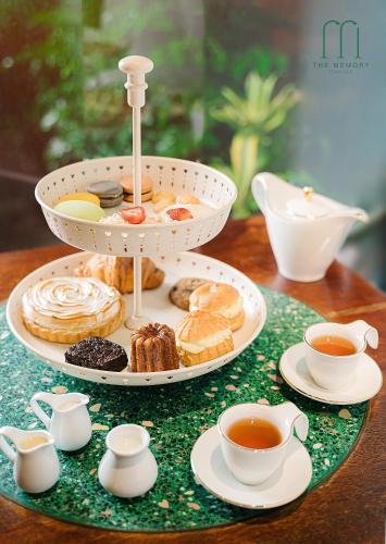 a plate of pastries and cups of tea on a table at The Memory - Danang in Da Nang