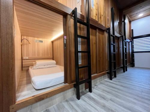 Cama pequeña en habitación con paredes de madera en Yong Guan, en Yuchi