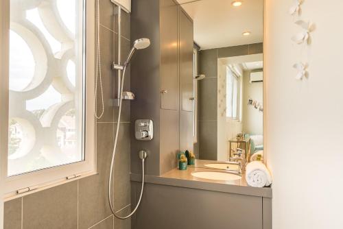 La salle de bains est pourvue d'une douche et d'un lavabo. dans l'établissement Annecy Lake, Luxury top floor apartment - LLA Selections by Location Lac Annecy, à Annecy