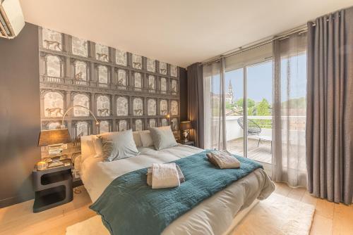 - une chambre avec un lit et une grande fenêtre dans l'établissement Annecy Lake, Luxury top floor apartment - LLA Selections by Location Lac Annecy, à Annecy