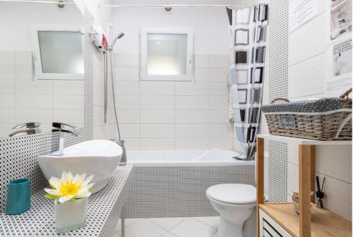 Un baño con bañera, inodoro y lavabo. en Moonlight Central Apartments, en Oradea