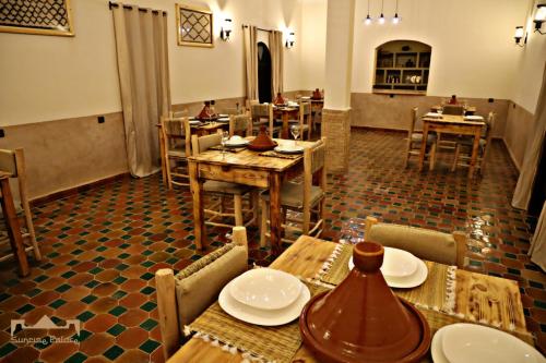 a dining room with wooden tables and chairs at Sunrise Palace Merzouga in Merzouga