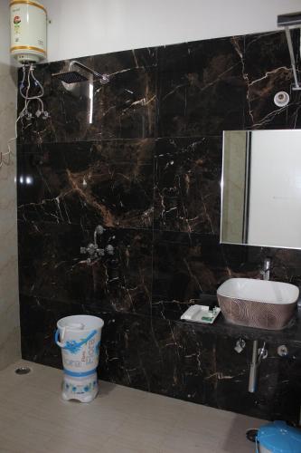a bathroom with a black marble wall with a sink at Chitrakoot Garden and Resorts in Pushkar
