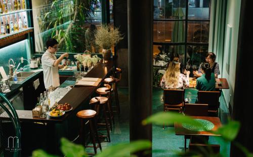 a group of people sitting at a bar in a restaurant at The Memory - Danang in Da Nang