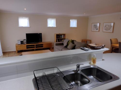 a kitchen with a sink and a living room at Cape View Villa- 74 in Broadwater