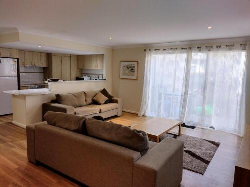 a living room with two couches and a kitchen at Cape View Villa- 74 in Broadwater