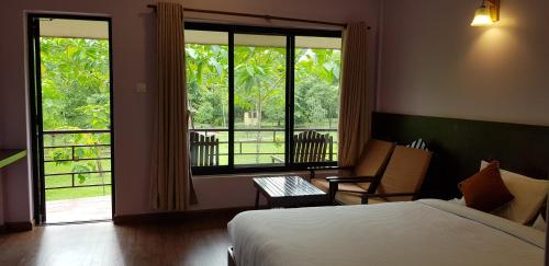 a bedroom with a bed and a large window at Lumbini Buddha Garden Resort in Lumbini