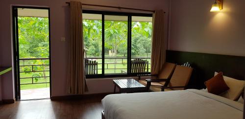 um quarto com uma cama e uma grande janela em Lumbini Buddha Garden Resort em Rummindei