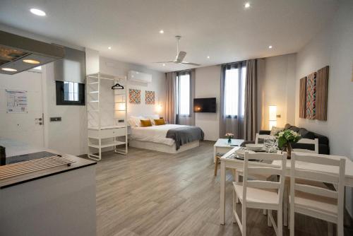 a living room with a bed and a dining room at EM21 Apartamentos in Córdoba