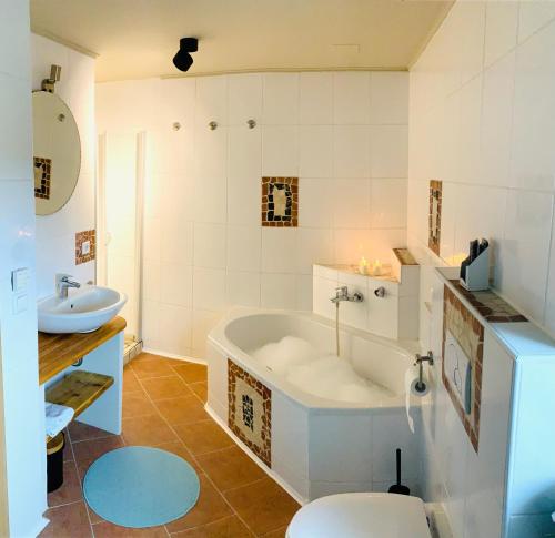 a bathroom with a tub and a toilet and a sink at Haus am See in Muhr amSee