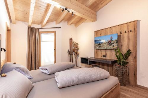 two beds in a room with wooden ceilings at Landhaus Sonnenwiese in Sölden
